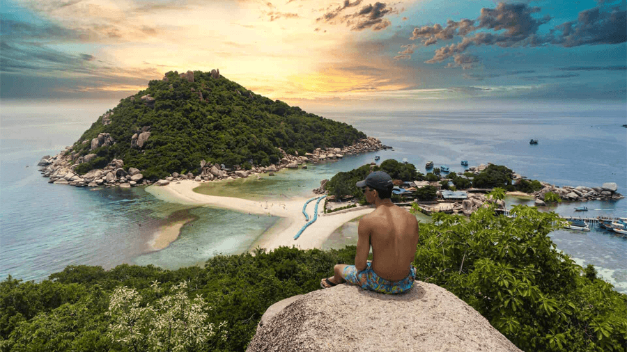 En man som sitter på en klippa i Thailand.